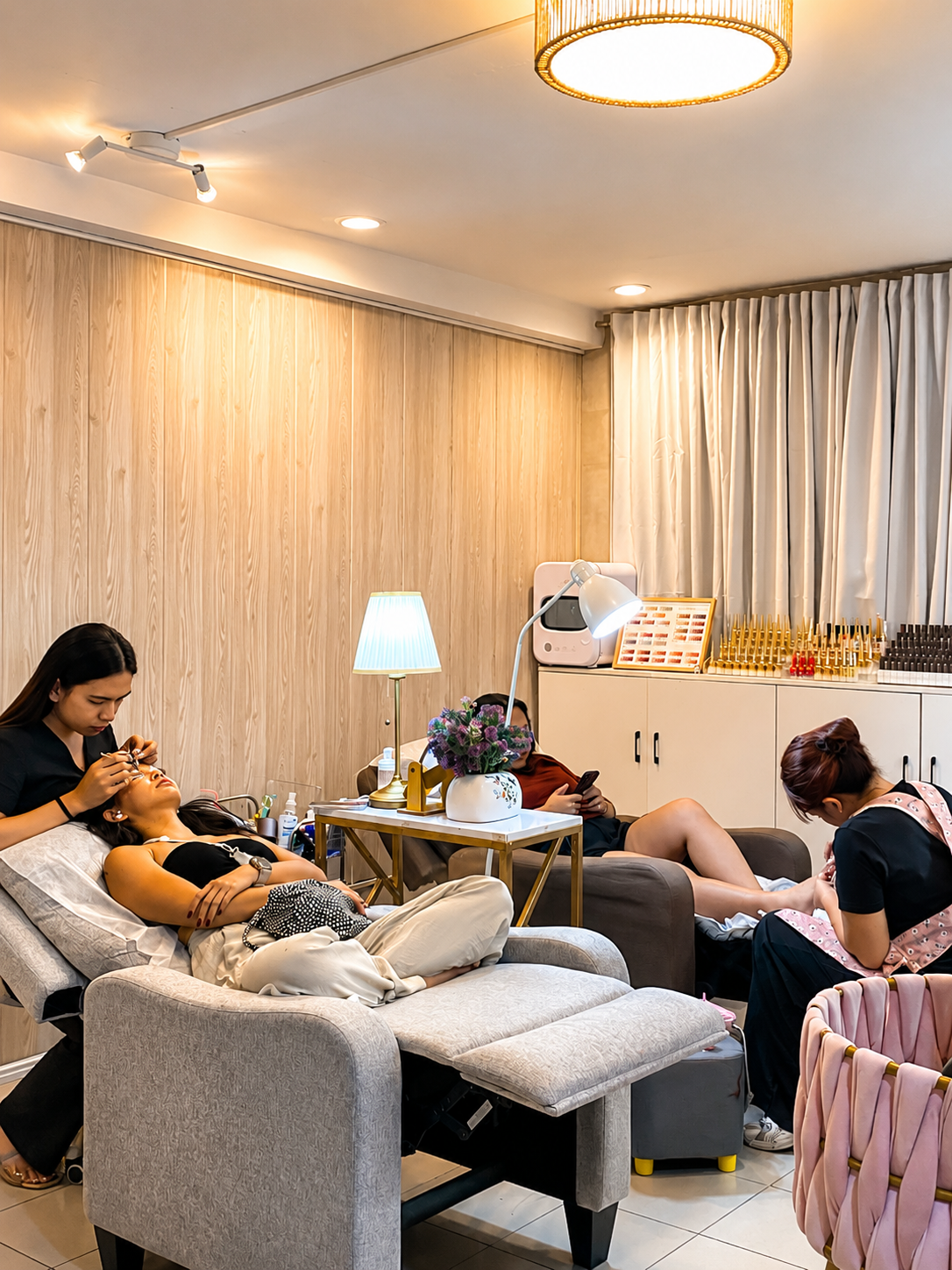 client relaxing during a lash treatment with pedicure chairs in the background, AyuriNails Beauty Lounge Makati